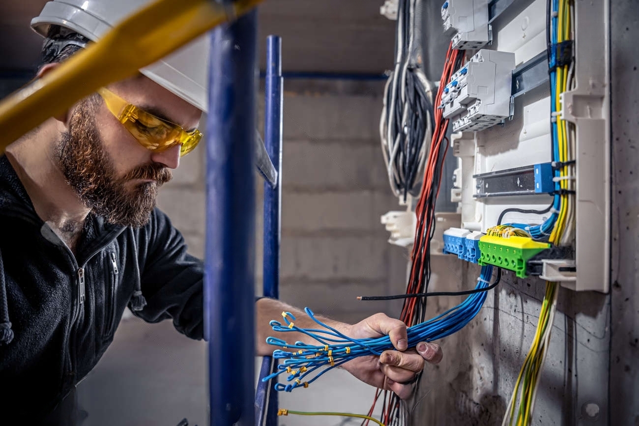 176560643-ein-elektriker-arbeitet-in-einer-schalttafel-mit-einem-elektrischen-verbindungskabel-transformed